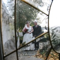 Dad and bride through the front door glass