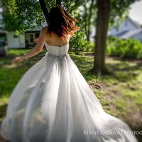 Creative Bridal Session tilt shift color photograph with bride twirling her dress in the sunlight